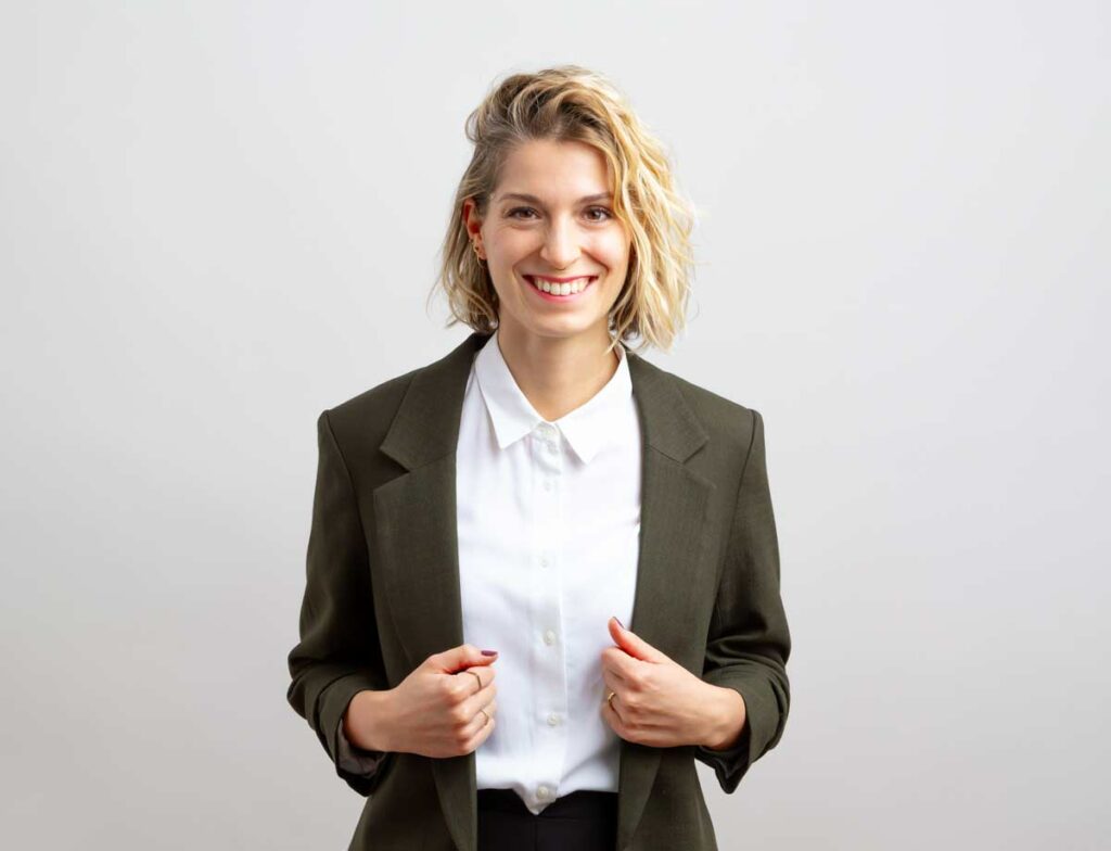 Foto der systemischen Coachin, Steffy Kämmerer, lachend vor Fotostudiohintergrund.